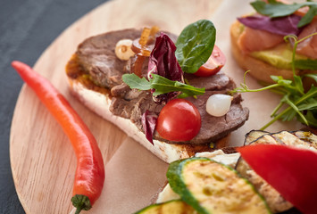 Bruschetta with fish, meat, vegetables and cheese on a wooden Board. Traditional Italian appetizer or appetizer, antipasto
