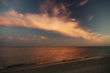 Seascape at sunset. Beautiful dark sky and light clouds
