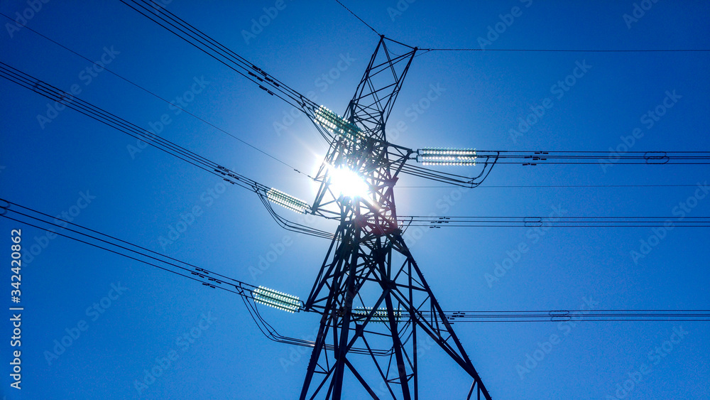 Wall mural low angle of power lines against blue sky and sun, johannesburg, south africa