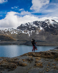 Fototapeta premium Couple by lake and mountain covered in snow