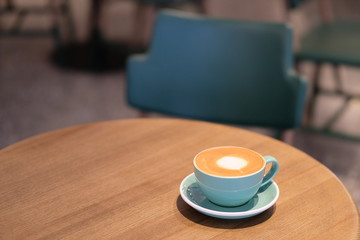 a cup of coffee on wooden table in cafe. blur background