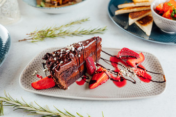 Homemade chocolate cake with strawberrie decoration on food table.