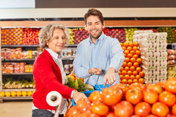 Obraz premium Senior woman and young man shopping while having vegetables