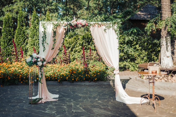 A beautiful wedding is set up. Square wedding ceremony. The rectangular arch is decorated with...