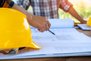 Engineer and architect discussing building plan at construction site,Group of builders having are...