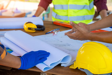 Engineer and architect discussing building plan at construction site,Group of builders having are...