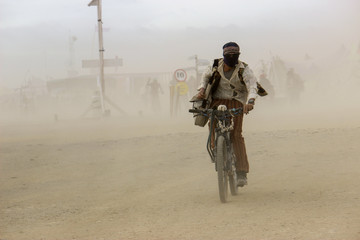 Man in a desert dust storm on a bicycle
