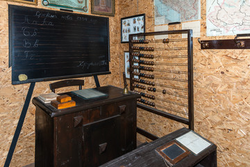 Vintage school classroom with wooden bench and desk and old blackboard. Old Serbian school classroom