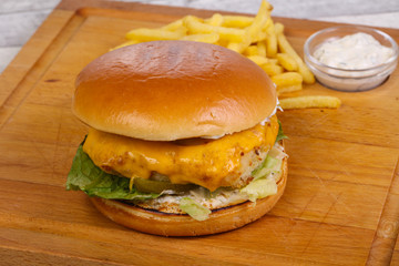 Homemade burger with fish, cheese and salad leaves