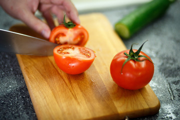 female hands cutting tomato