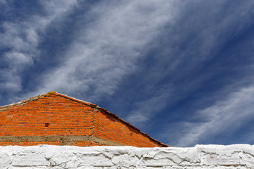 Arquitectura rural. Tapia, fachada de ladrillos y cielo azul con nubes. San Pedro de las Dueñas,...