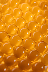 Fish oil capsules. Many round tablets of red-orange color.