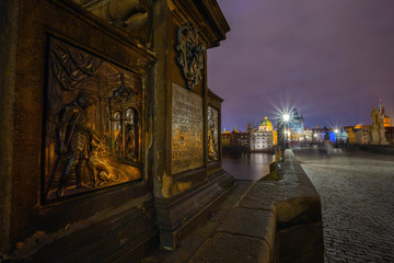 night landscape on Charles bridge in Prague, sculptures and the old town