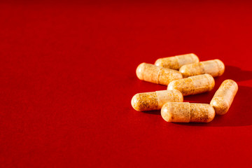 Vitamin pills on a red background