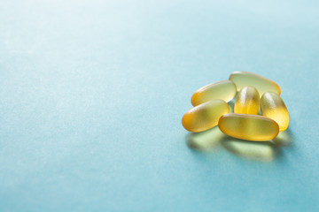 Cod liver oil omega 3 gel capsules on blue background