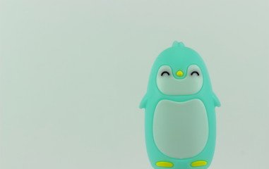 A close up color image of a green and white baby penquin with a white background.