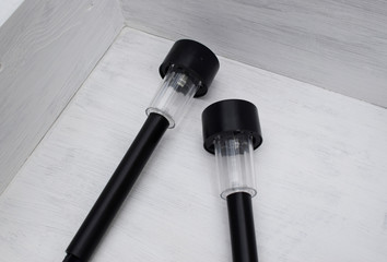 Two solar-powered street lamps in a white wooden box. Garden lights. View from above.