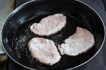 Cooking chops in a pan shot close-up.
