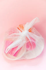 Plastic waste in a bag on a pink background. Concept of plastic recycling and the environment. Flatlay top view, Selective focus