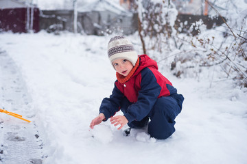 Maltymrbq boy in warm jumpsuit plays with snow