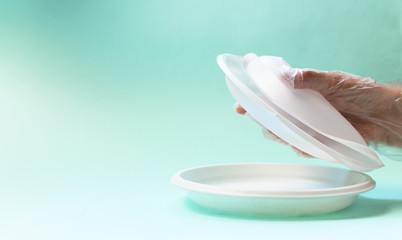 Plastic waste in a gloved hand on a blue background. Concept of plastic recycling and the environment. Selective focus