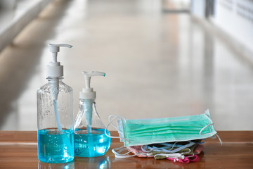 Hand sanitizer gel and facemasks in front of the office's doors for the officers to clean hands and wear before getting inside to protect and prevent Covid-19 virus or Coronavirus and germs.