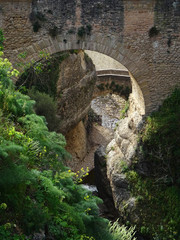 Fototapeta na wymiar Old Christian Bridge -17 Century- and in the rear, Arabic Bridge -14 Century- in the city of Ronda. Spain.