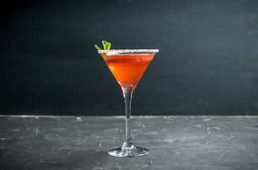 Red cocktail with bloody oranges in martini glass on the rustic background. Selective focus. Shallow depth of field.