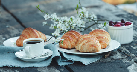 Freshly backed croissants with berries and coffe