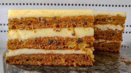 Layers of carrot cake with cream cheese frosting.

