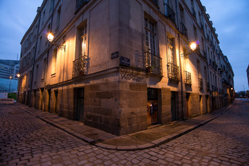 Fototapeta na wymiar Aube sur rue croisé symétrique d'un bâtiment du XIXᵉ du centre-ville de Nantes en France
