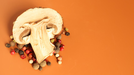 one brown royal champignon on a yellow background with a mixture of peppers. Such mushrooms resemble the taste of porcini mushrooms and have a more pronounced mushroom taste and smell. Copy space.