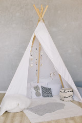 Nursery in Scandinavian style. Scandi child room interior in real photo. Decorative boho styled hut, tipi, wigwam © paralisart