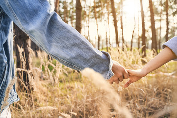 Man holding his girlfriends hand in a forest