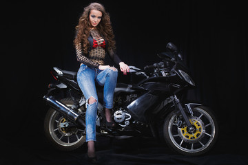 Fototapeta na wymiar beautiful sexy model posing on a motorcycle in a photo Studio.