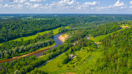 Panoramic aerial view photo from flying drone on beautiful forests of Sigulda, the meadows, and the flowing river Gauja. Sigulda, Latvia in summer (series)