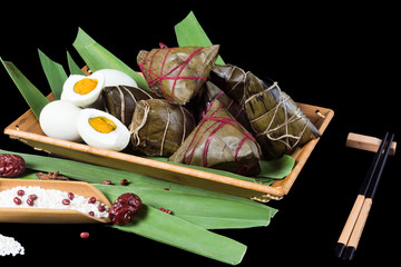 Asian Chinese rice dumplings on basket, tea at background.