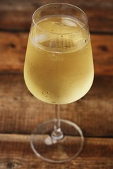 A glass of white wine on a wooden table
