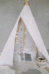 Nursery in Scandinavian style. Scandi child room interior in real photo. Decorative boho styled hut, tipi, wigwam © paralisart