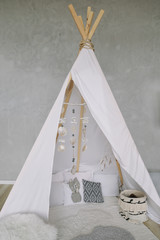 Nursery in Scandinavian style. Scandi child room interior in real photo. Decorative boho styled hut, tipi, wigwam © paralisart