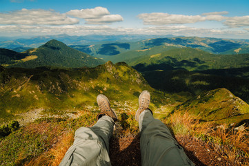Naklejka premium Legs of hiker relaxing on mountains