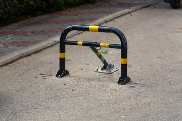 Ground mounted three leg parking barrier post. Fold down vehicle security car parking lock safety barrier mounted on paved parking lot