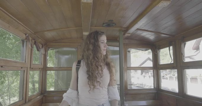 Young woman gets on wooden Vintage Train, Fashion Model face, smiling and beautiful, touristic place, s-log, Ungraded
