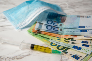covid19 vaccine and euro banknotes with medical mask. coronavirus economic breakdown