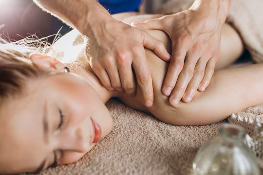 Close up of boyfriend giving relaxing massage for his girlfriend. Romantic and intimate atmosphere.Home relaxation, beauty and massage.Couple enjoying relationship and relax wellness treatment concept