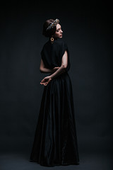 Aristocratic girl. Girl in a black dress with a tiara on her head.