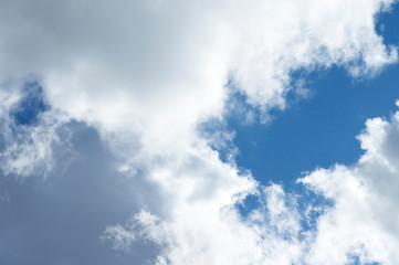 Thick clouds in the blue sky. Background photo of clouds where the sun shines through.
