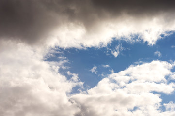 Thick clouds in the blue sky. Background photo of clouds where the sun shines through.