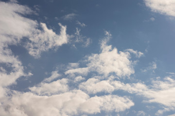 Thick clouds in the blue sky. Background photo of clouds where the sun shines through.