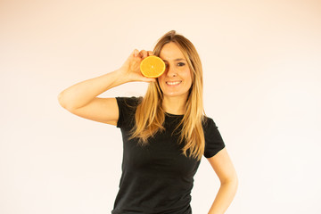 Smiling pretty woman showing an orange